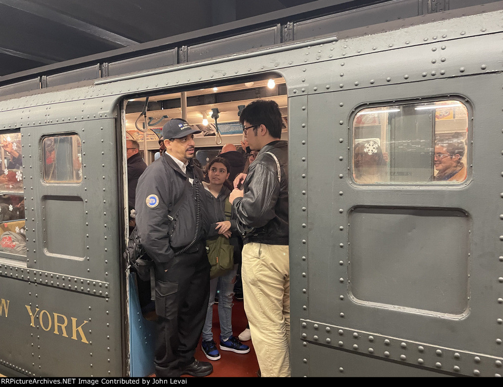 An MTA employee conversing with a passenger in the Arnine Car at 2nd Ave Station 